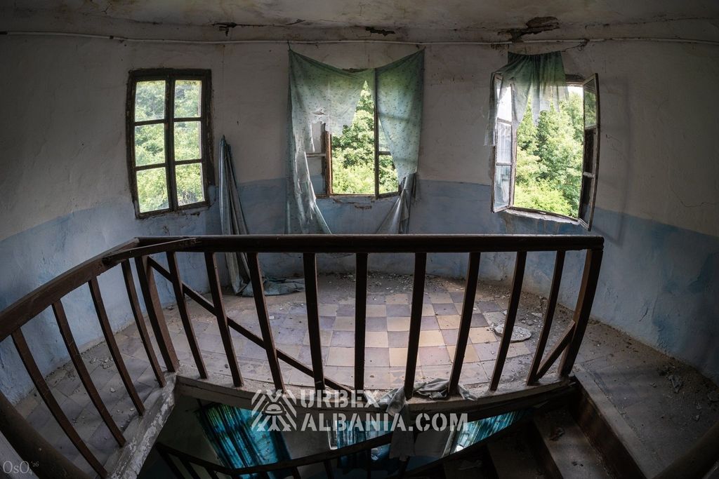 Rideaux déchirés pendant à la fenêtre d'une chambre des étages supérieurs du sanatorium