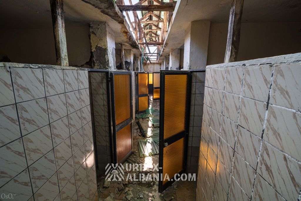Long couloir du bâtiment des bains du sanatorium bordé de portes menant aux cabines de soins