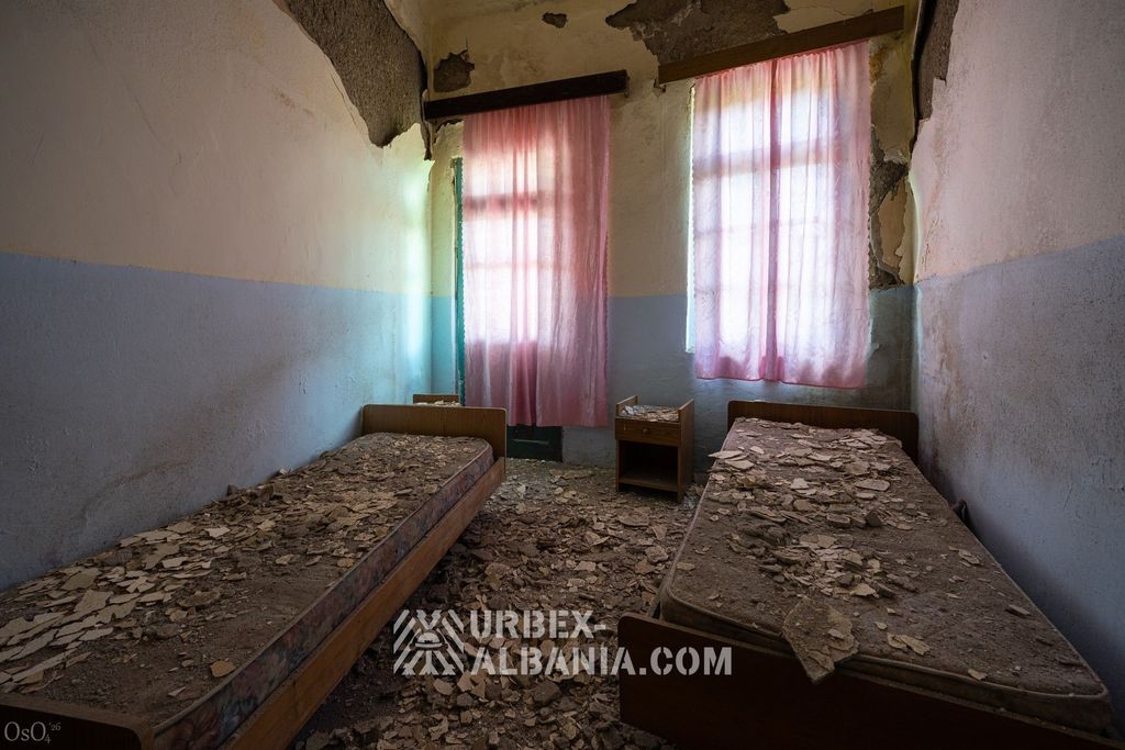 Chambre du dernier étage au plafond effondré, plâtre répandu sur les lits et le sol