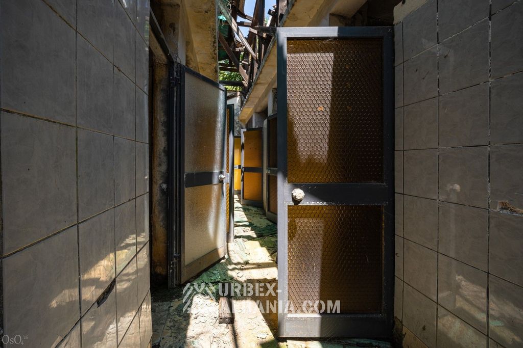 Rangée de cabines de bains numérotées le long du couloir de l'établissement thermal