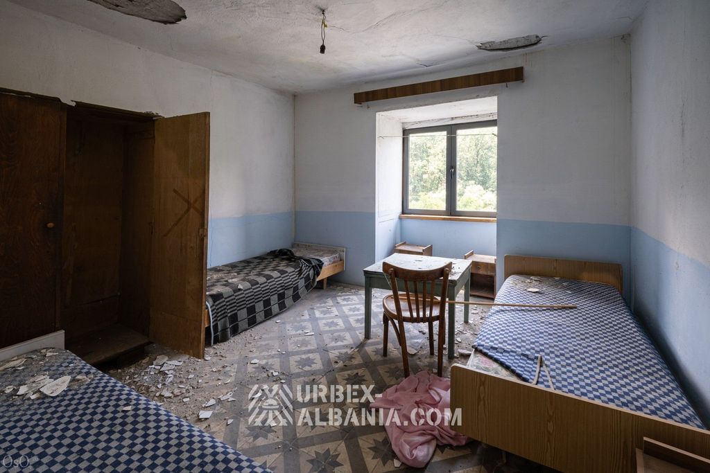 Chambre à trois lits alignés le long des murs dans l'hôtel thermal abandonné
