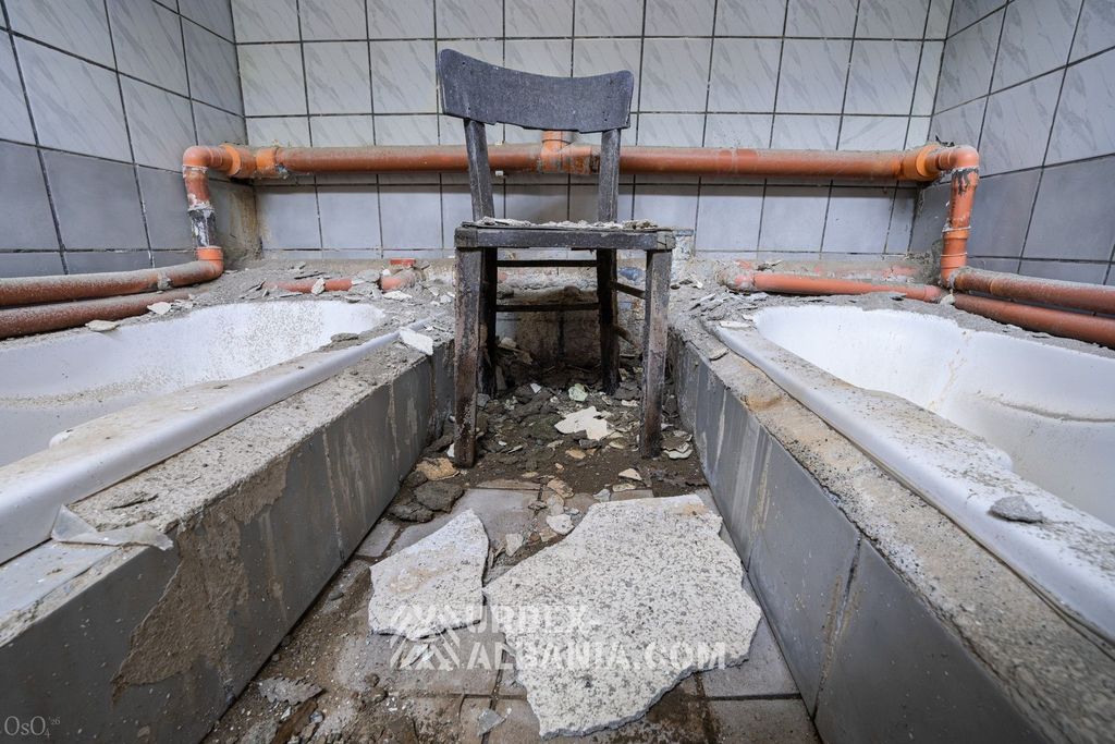 Deux bassins mitoyens dans une cabine commune, carrelage fissuré et terni par l'eau minérale