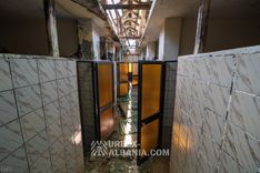 Long couloir du bâtiment des bains du sanatorium bordé de portes menant aux cabines de soins