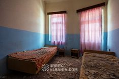 Chambre du sanatorium meublée de lits et d'une armoire mais sans salle de bains privative