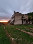 Podupadłe koszary wojskowe z małym bunkrem