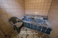 Bassin monumental carrelé encastré dans le sol d'une cabine du sanatorium