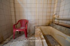 Murs écaillés d'une cabine de bains marqués de coulures dues à l'humidité et à la vapeur thermale
