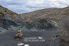 Фронтальный погрузчик, сортирующий хромитовую руду в кучи на чёрной земле отвала
