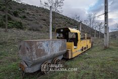 Электровоз с вагонеткой, брошенный в траве у пути