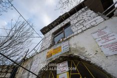 Кот, сидящий в окне будки охраны над порталом штольни