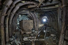 Вагонетка рядом с обрушением, просыпавшимся сквозь арочную крепь выработки