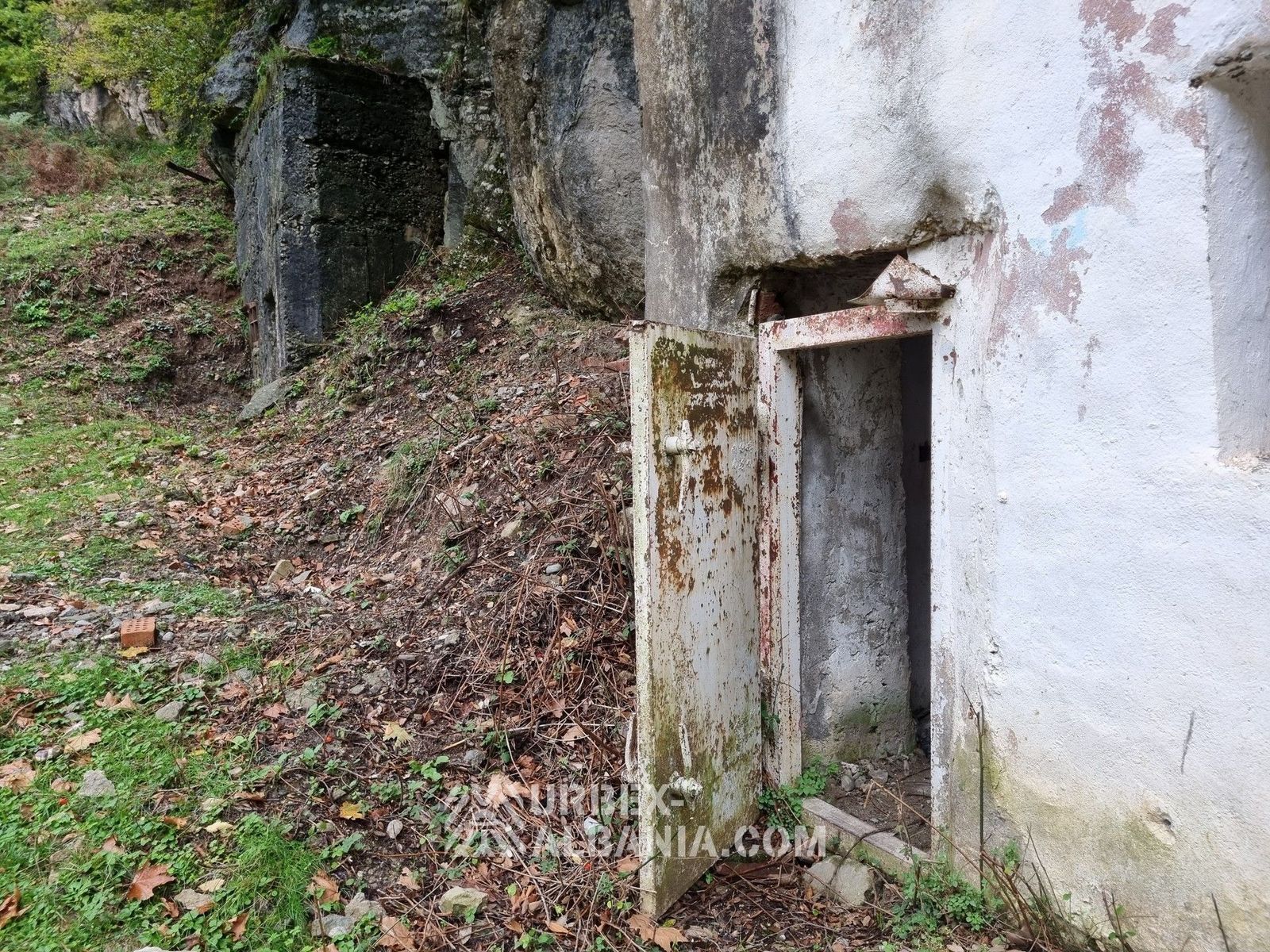 Podupadłe koszary wojskowe z małym bunkrem