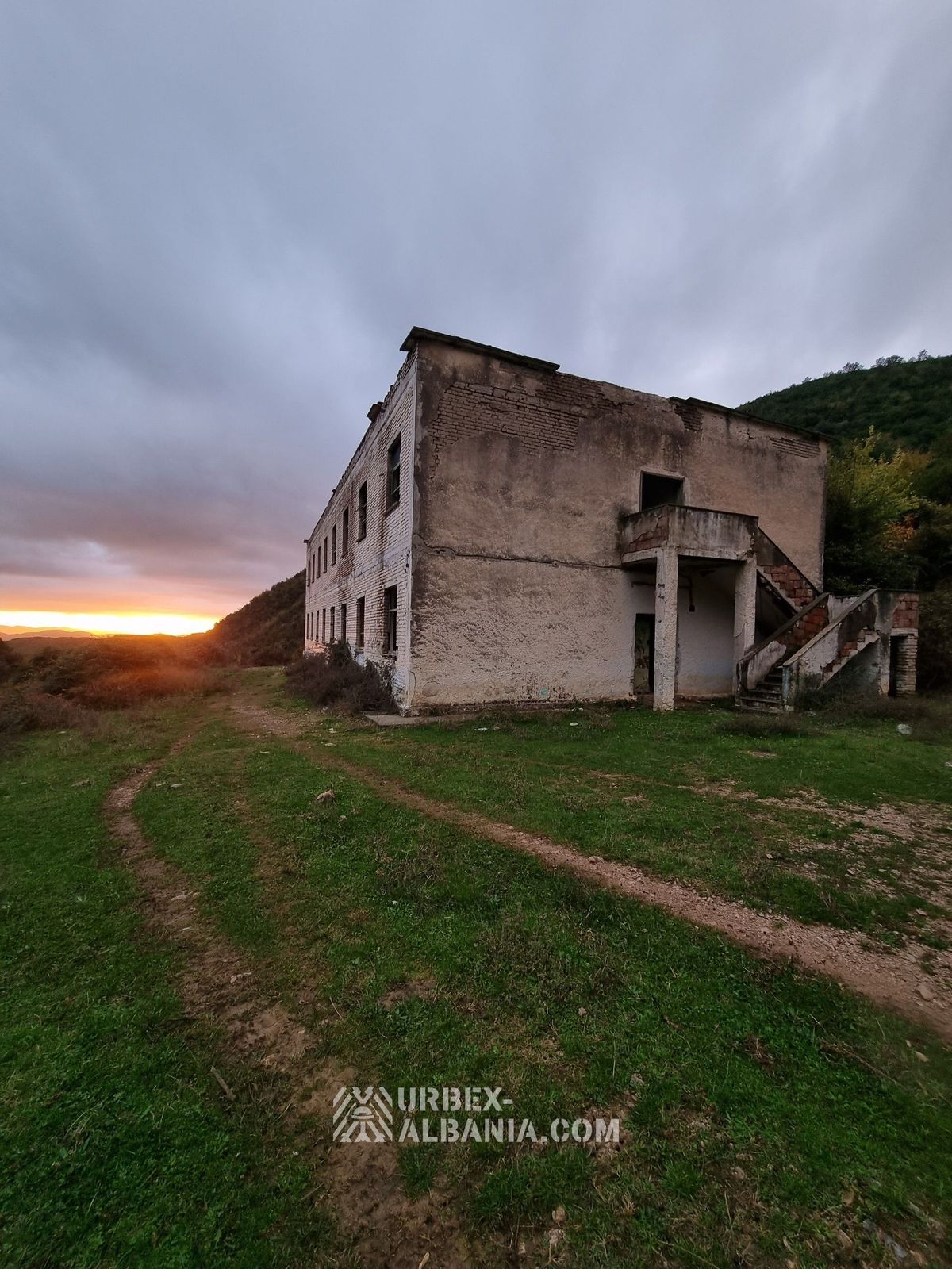 Podupadłe koszary wojskowe z małym bunkrem